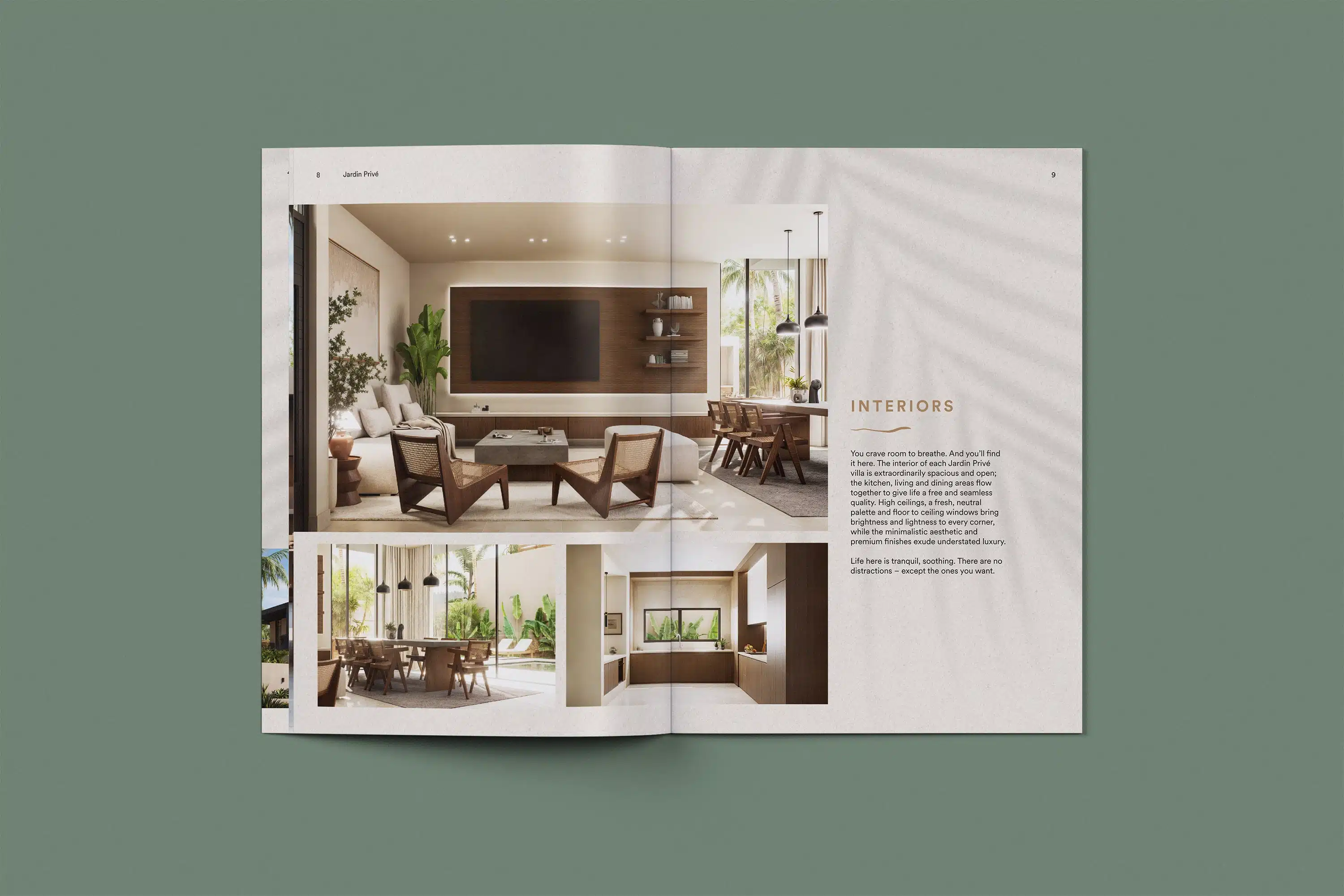 Open spread of the Dune Signature Oasis brochure, featuring photographs of villa interior spaces. The top photograph shows a living area with a sofa, armchairs, a television, and a dining table. The bottom left photograph shows a dining area with a table and chairs, and a view of the outdoor patio. The bottom right photograph shows a kitchen counter with a sink and cabinets. The text 'INTERIORS' is visible at the top right, followed by paragraphs of descriptive text. A faint palm tree shadow pattern is visible on the right page. The brochure is shown at an angle on a grey-green background. This image showcases the luxury property brochure design, using interior photography and a clean layout to highlight the villas' living spaces and design details.